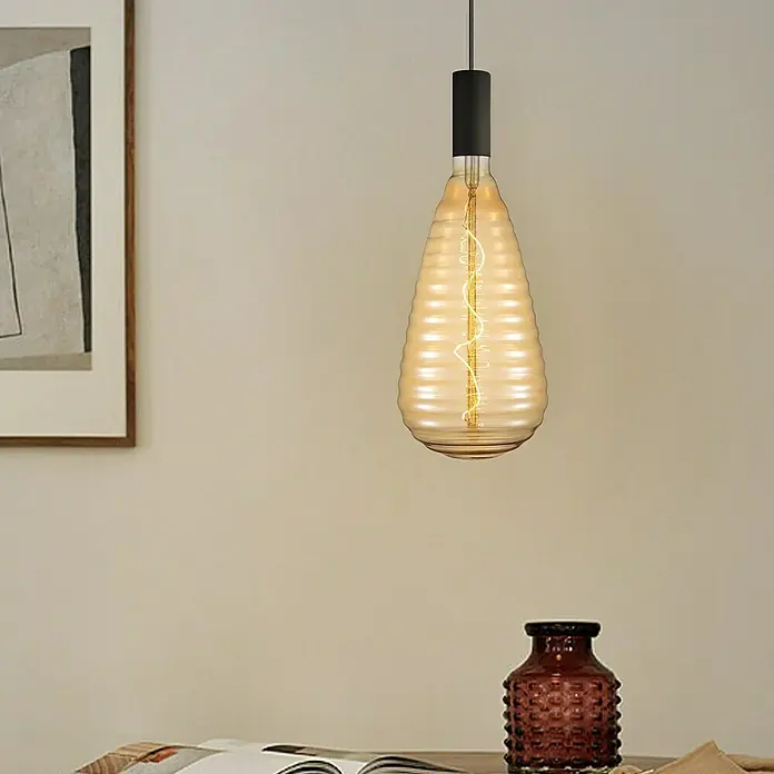 Home Sweet Home LED-Lampe Vintage Globe-Form E27 - E27, Dimmbar, Warmweiß, 280 lm, 4 W - Ein stilvolles Foto zeigt eine dekorative Retro-Glühbirne mit einem einzigartigen Design und warmem Licht in einem eleganten Interieur.