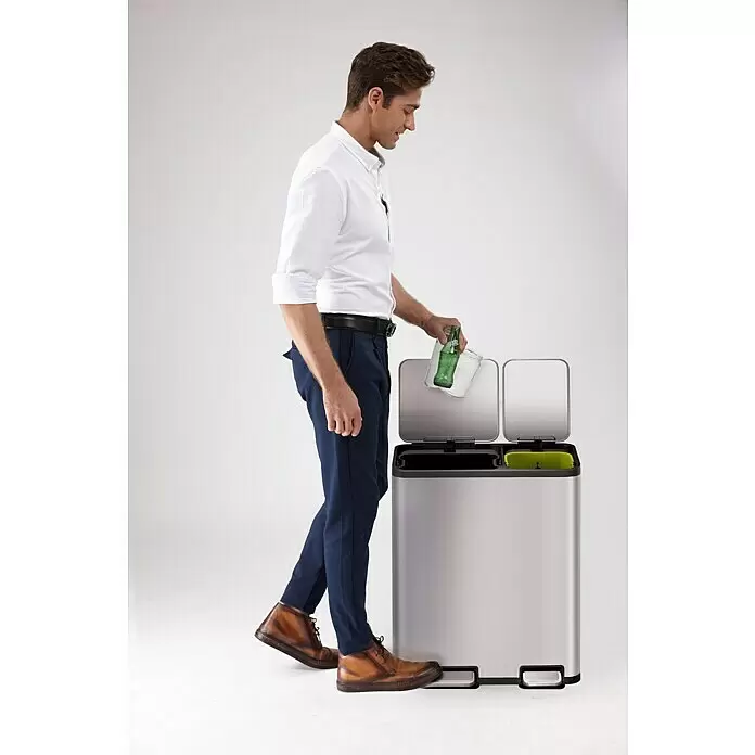 Vepa Bins Treteimer EcoCasa - 50 l, Edelstahl, Mattsilber - Ein Mann entsorgt eine Glasflasche in einem silbernen Doppelkammer-Treteimer zum Recycling.