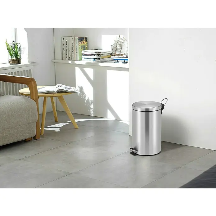 Vepa Bins Treteimer Trittmülleimer Venus - 12 l, Metall, Edelstahl - Ein moderner, runder Treteimer aus gebürstetem Edelstahl steht in einem hellen Raum mit Fliesenboden. Praktisch und stilvoll für jeden Raum.
