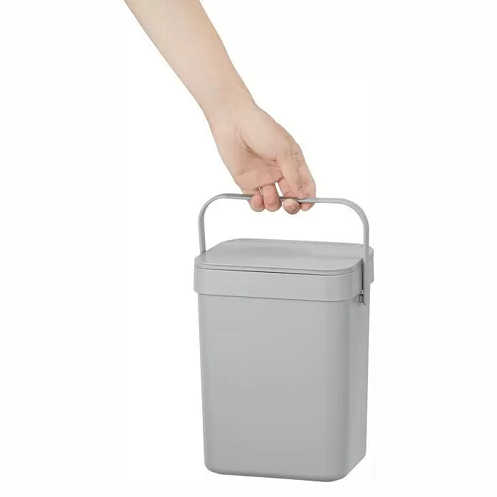 Vepa Bins Standard Mülleimer Foodwaste Caddy Puro II - 5 l, Kunststoff, Grau - Hellgrauer rechteckiger Behälter mit Deckel und Griff, von einer Hand gehalten.