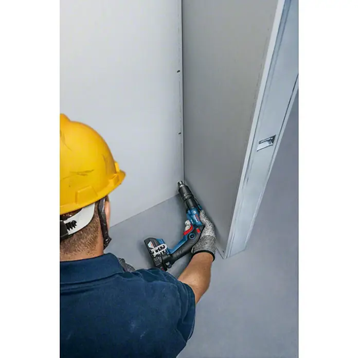 Bosch Professional AMPShare 18V Atornillador para placas de yeso de batería GTB 18V-45 - 18 V, 2 baterías, 6 Nm, Número de revoluciones de marcha en vacío 1ª marcha: 0 r.p.m. - 4.500 r.p.m. - Artesano utilizando un taladro/atornillador inalámbrico Bosch mientras trabaja en una pared. El taladro/atornillador es azul y negro.