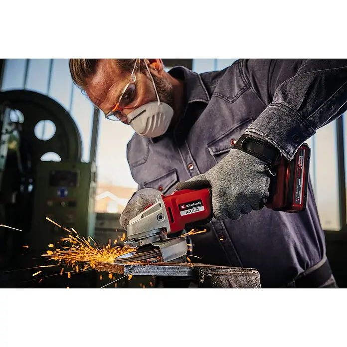 Einhell Professional PXC 18V Amoladora angular de batería Axxio 18/125 Q - Sin batería, Diámetro disco: 125 mm, 8.500 r.p.m. - Hombre con gafas de seguridad y máscara, usando una amoladora angular Einhell AXXIO sobre metal, con chispas.