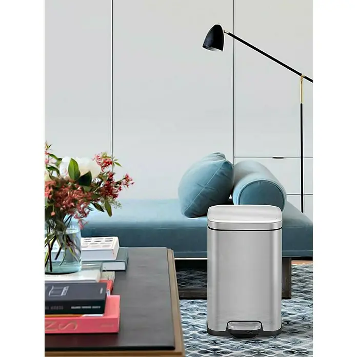Vepa Bins Treteimer Stella - 12 l, Edelstahl, Mattsilber - Ein moderner, rechteckiger, silberner Treteimer mit einem weißen Deckel steht in einem stilvollen Wohnzimmer.