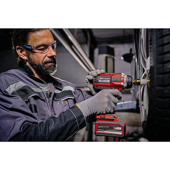 Einhell Professional PXC 18V Llave de impacto de batería IMPAXXO 18/400 - 18 V, Sin batería, 450 Nm - Un hombre que usa una llave de impacto inalámbrica Einhell IMPACTX0 para apretar una tuerca de orejeta en un vehículo.