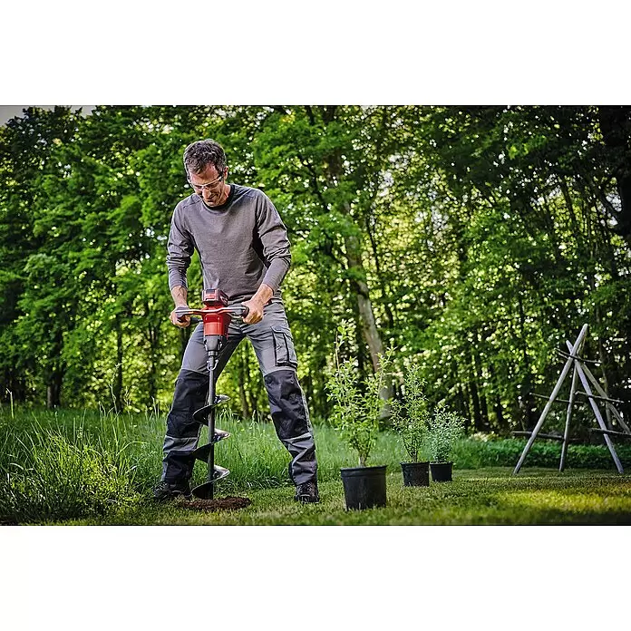 Einhell Professional PXC 18V Taladradora de suelo de batería - 18 V, Sin batería, Diámetro: 150 mm - Hombre usa un taladro de tierra rojo y negro para hacer un agujero y plantar árboles jóvenes.