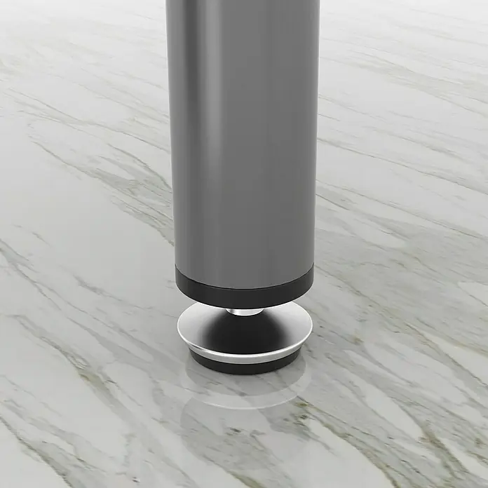 Rei Tornillo regulable - Cromo, 4 ud. - Primer plano de una pata de mesa gris con pie plateado sobre una superficie de mármol, diseño moderno y minimalista.