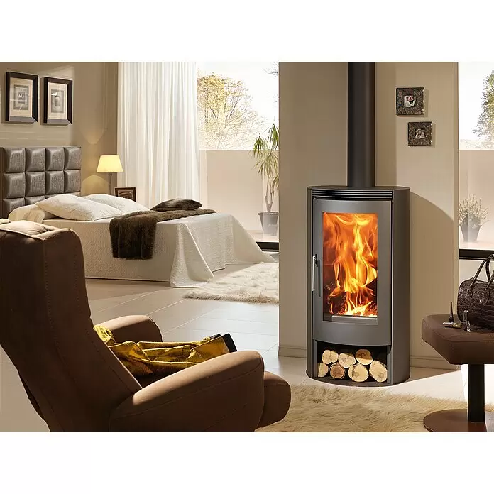 Panadero Kaminofen Delta Eco - 8 kW, Raumheizvermögen: 240 m³, Material Verkleidung: Stahl, Schwarz - Dunkelgrauer Holzofen mit sichtbaren Flammen und Holzscheitablage, schafft eine gemütliche Schlafzimmeratmosphäre.