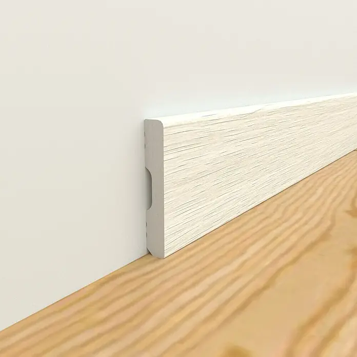 Oknum Rodapié Everest - 200 cm x 14 mm x 90 mm - Primer plano de un zócalo de madera blanca, instalado entre una pared blanca y un piso de madera clara.