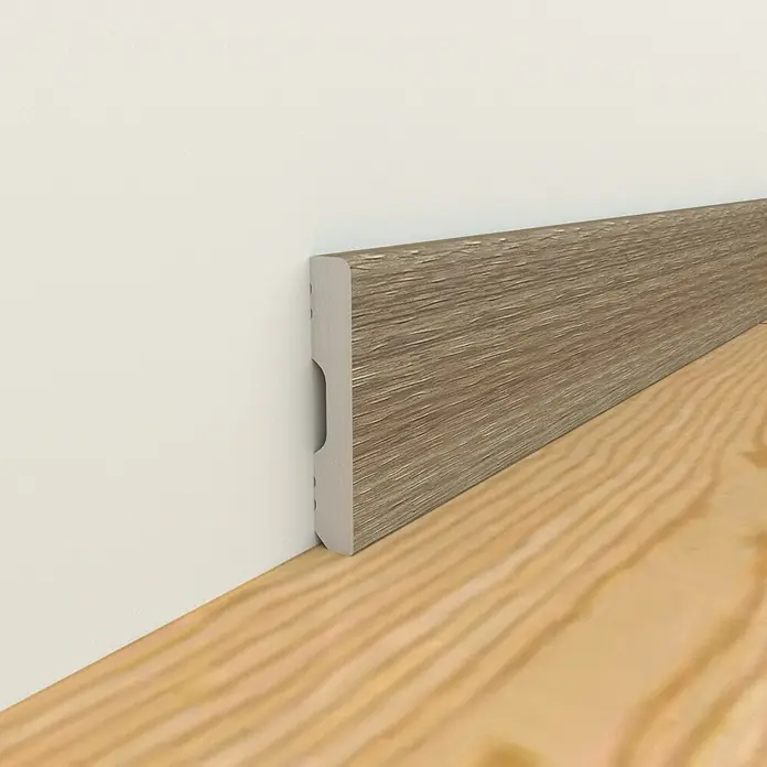 Oknum Rodapié Etna - 200 cm x 14 mm x 90 mm - Un zócalo de aspecto de madera instalado entre una pared blanca y un piso de madera agrega un toque elegante a la habitación.