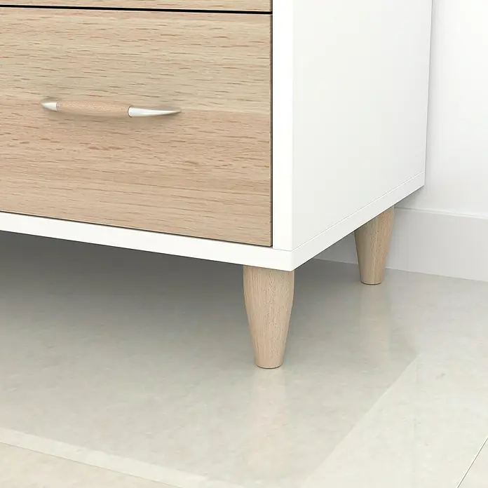 Rei Möbelfuß - Holz, Ø x L: 5 x 12 cm, Unbehandelt - Nahaufnahme eines weißen Schranks mit hellbraunen Schubladen und Holzbeinen, der ein modernes Möbelstück zeigt.