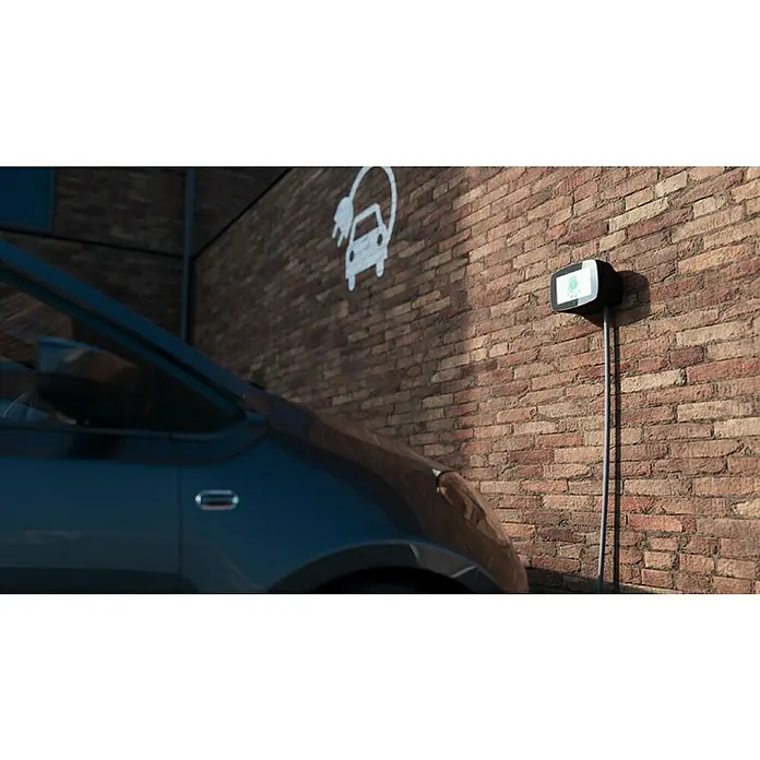 Wallbox Cargador para automóvil Commander 2 - 22 kW, 32 A, Negro - Primer plano de una estación de carga para coches eléctricos en una pared de ladrillo junto a un coche, lo que agiliza la experiencia de carga de vehículos eléctricos.