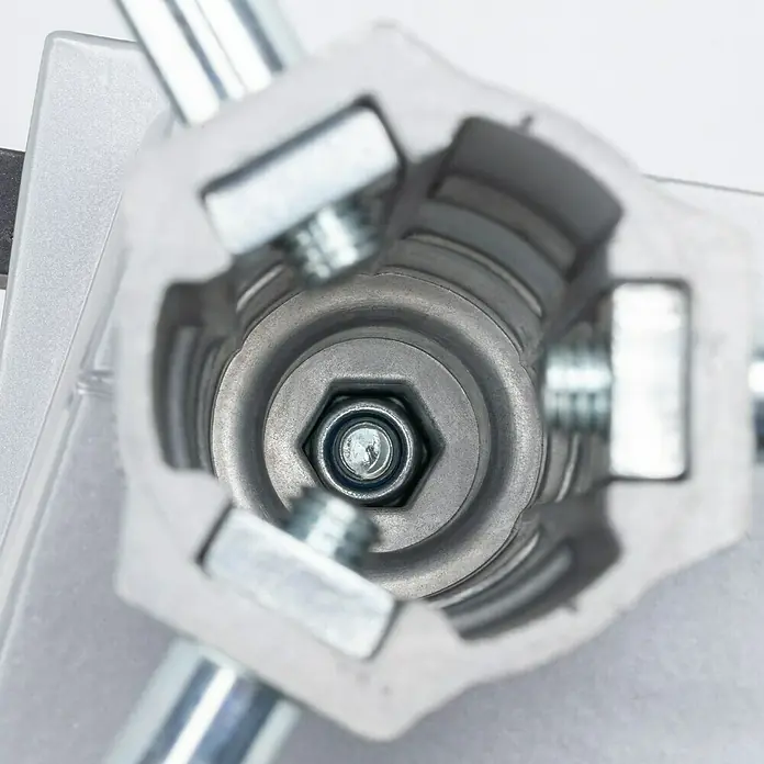 Wolfcraft Soporte de taladro - L x An x Al: 307 x 203 x 570 mm, Apertura máxima: 60 mm - Primer plano de un dispositivo plateado con tornillos y una tuerca hexagonal central, destacando su precisión y funcionalidad.