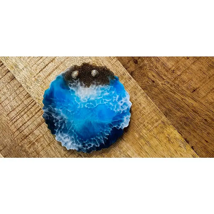 Epoxidharz Oberflächenharz Brilliant Shine - Glasklar, 7,5 l - Kunstharz-Untersetzer mit einem Ozean-Design, das Strand, Sand und Muscheln zeigt. Eine elegante Ergänzung für jeden Tisch.