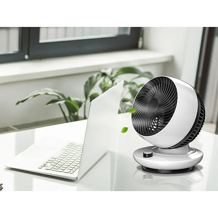 Purline Venty Ventilador de sobremesa TA 45 - Blanco y Negro, 27 cm - Un ventilador de mesa blanco con rejilla negra sobre un escritorio junto a una computadora portátil, proporcionando una brisa refrescante.