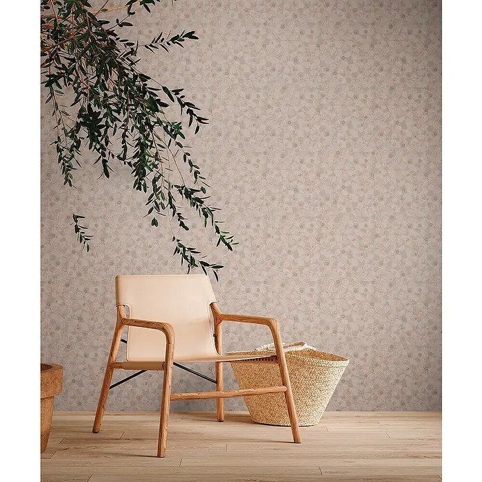 A.S. Création Metropolitan Stories Travel Styles Vliestapete Blätter-Allover II - Rosè, Floral, 10,05 x 0,53 m - Elegantes Interieur mit einem hellen Sessel aus Holz und Leder neben einem Korb, dekoriert mit einem grünen Zweig vor gemusterter Wand.