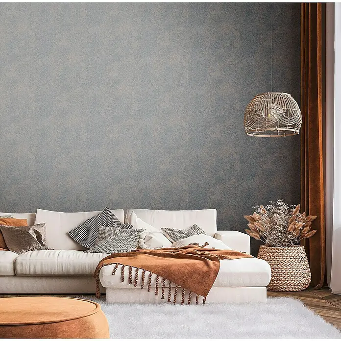 A.S. Création Metropolitan Stories Travel Styles Vliestapete Allover II - Schwarz/Kupfer, Grafisch, 10,05 x 0,53 m - Wohnzimmer mit weißem Sofa, dekorativen Kissen, brauner Tagesdecke, flauschigem Teppich und einer dekorativen Hängelampe.