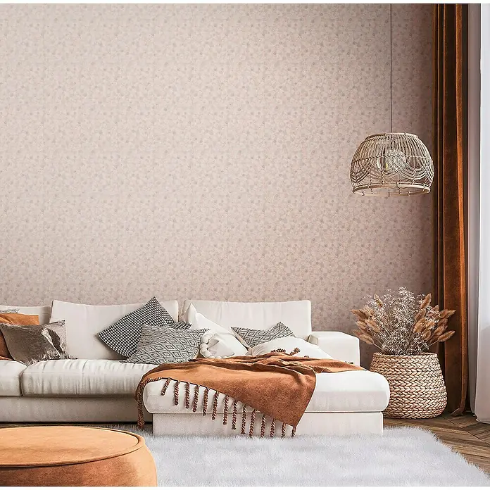 A.S. Création Metropolitan Stories Travel Styles Vliestapete Blätter-Allover II - Rosè, Floral, 10,05 x 0,53 m - Gemütliches Wohnzimmer mit weißem Sofa, brauner Decke und passendem Lampenschirm für eine warme Atmosphäre.
