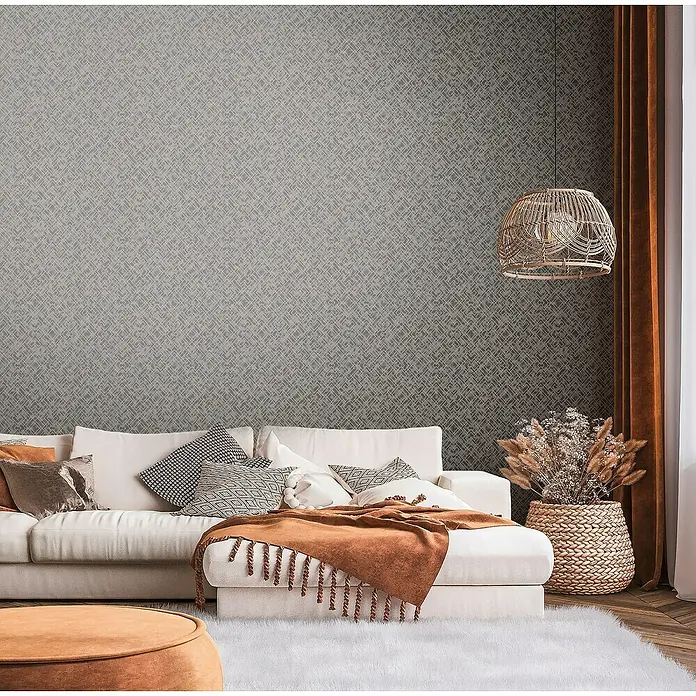 A.S. Création Metropolitan Stories Travel Styles Vliestapete Allover I - Schwarz/Gold, Grafisch, 10,05 x 0,53 m - Wohnzimmer mit einem weißen Sofa, braunen Akzenten und einer dekorativen Wand, die eine gemütliche und stilvolle Atmosphäre schafft.