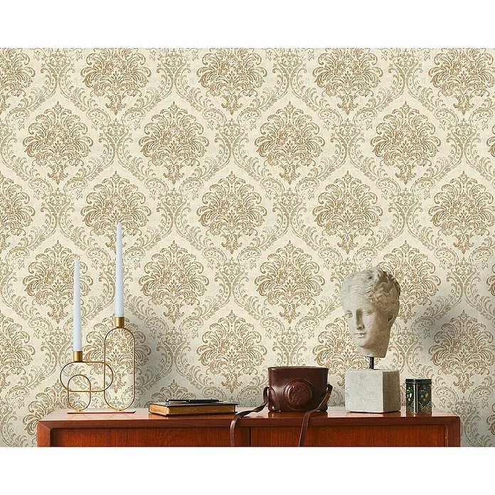 A.S. Création Metropolitan Stories Travel Styles Vliestapete Damask - Creme/Gold, Ornament, 10,05 x 0,53 m - Detailaufnahme einer klassischen Inneneinrichtung mit einer Stuckbüste und dekorativen Gegenständen vor einer verzierten Tapete.