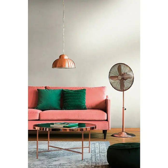 A.S. Création Metropolitan Stories Travel Styles Vliestapete - Creme, Grafisch, 10,05 x 0,53 m, Matt - Zimmer mit einem rosafarbenen Sofa, smaragdgrünen Kissen, einem kupferfarbenen Ventilator und einer passenden Hängelampe.