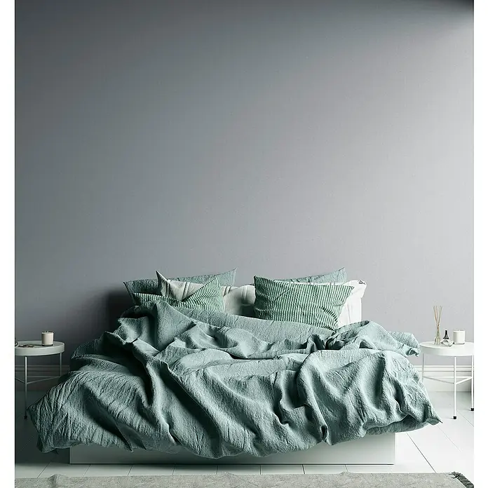 A.S. Création Metropolitan Stories Travel Styles Vliestapete - Melange-Hellgrau, Uni, 10,05 x 0,53 m - Elegantes Schlafzimmer mit einem großen Bett, das mit mintgrüner Bettwäsche und gestreiften Kissen dekoriert ist, für einen ruhigen Rückzugsort.