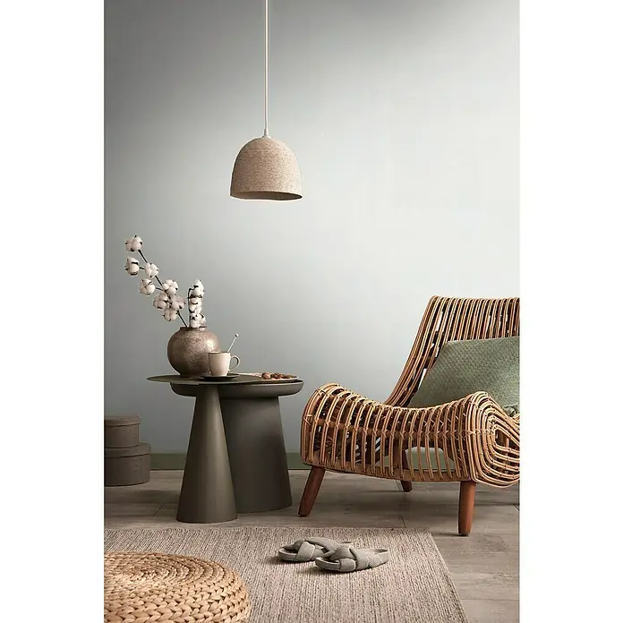 A.S. Création Metropolitan Stories Travel Styles Vliestapete - Melange-Weiß, Uni, 10,05 x 0,53 m - Zimmerinterieur mit einer Pendelleuchte aus Seil über einem Beistelltisch und einem Rattan-Sessel für eine gemütliche Atmosphäre.