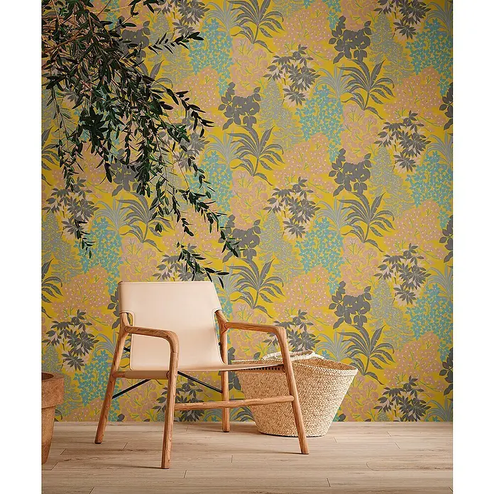 A.S. Création Metropolitan Stories Travel Styles Vliestapete Blumen I - Gelb, Floral, 10,05 x 0,53 m - Elegantes Interieur mit einem hellen Lederstuhl aus Holz, einem Strohkorb und einer auffälligen floralen Tapete im Hintergrund.
