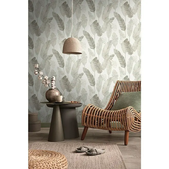 A.S. Création Metropolitan Stories Travel Styles VliestapeteCreme/Beige, Floral, 10,05 x 0,53 m - Elegantes Interieur mit Blattmuster-Tapete, einem Naturfaser-Lampenschirm und einem Rattan-Sessel, der eine entspannende und stilvolle Atmosphäre schafft.