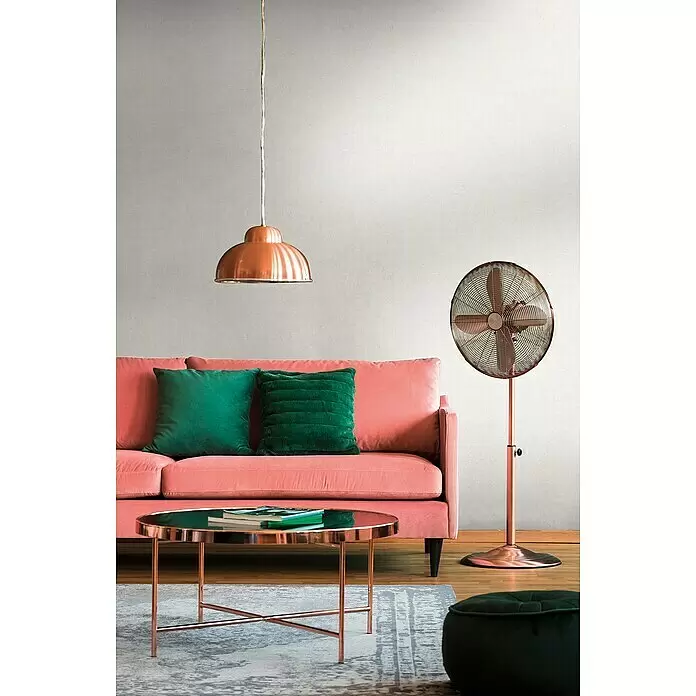 A.S. Création Metropolitan Stories Travel Styles Vliestapete - Creme, Uni, 10,05 x 0,53 m, Feine Struktur - Ein stilvolles Wohnzimmer mit einem rosa Sofa, grünen Kissen, einer kupfernen Pendelleuchte, einem kupfernen Ventilator und einem kupfernen Couchtisch.