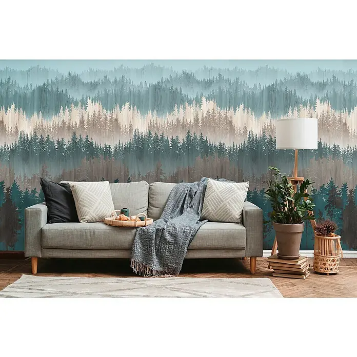A.S. Création Metropolitan Stories Travel Styles Fototapete Wald - B x H: 1,59 x 2,8 m, Vlies, Blau/Beige - Detailansicht eines Wohnzimmers mit einem grauen Sofa, Kissen, einer Decke und einem Tablett mit Lebensmitteln vor einer Waldtapete.