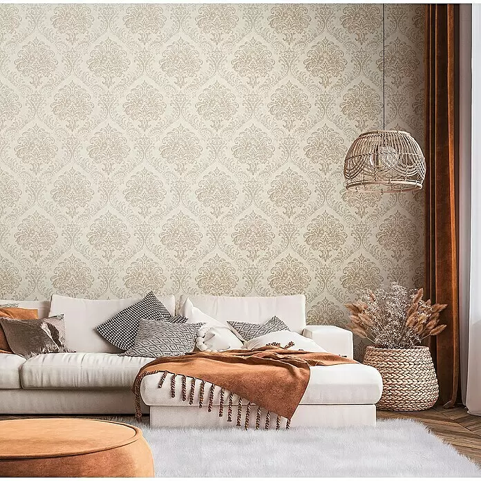 A.S. Création Metropolitan Stories Travel Styles Vliestapete Damask - Creme/Gold, Ornament, 10,05 x 0,53 m - Beige-goldene Damast-Muster-Tapete an einer Wohnzimmerwand.