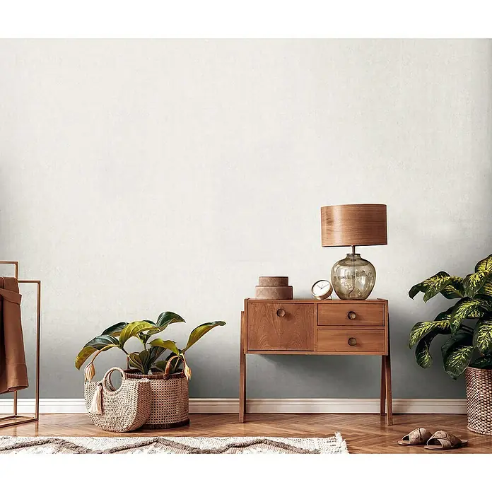 A.S. Création Metropolitan Stories Travel Styles Vliestapete - Creme, Uni, 10,05 x 0,53 m, Feine Struktur - Gemütliches Interieur mit einem Holzschrank, einer Lampe und Pflanzen. Der Holztisch dient als Ablagefläche und verleiht dem Raum Wärme.
