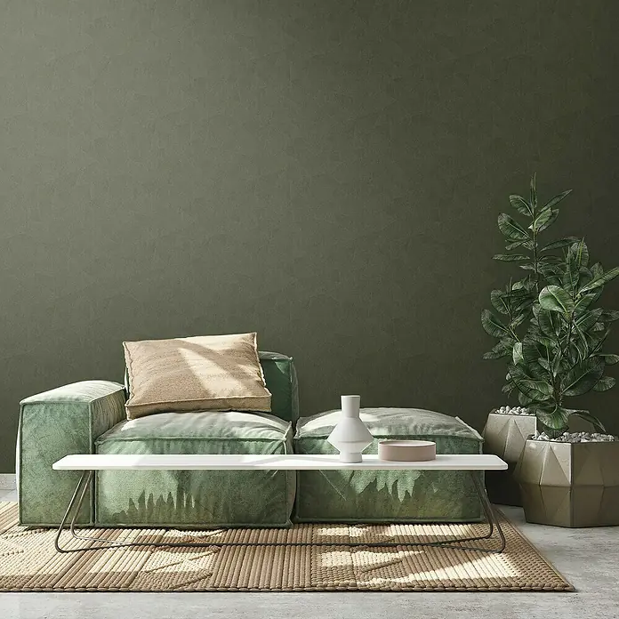 A.S. Création Metropolitan Stories Travel Styles Vliestapete - Grün, Grafisch, 10,05 x 0,53 m, Matt - Ein grünes modulares Sofa mit einem Kissen und einem niedrigen Tisch mit einer Vase, perfekt für ein modernes Wohnzimmer.
