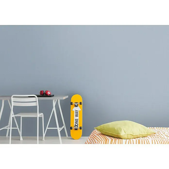 A.S. Création Metropolitan Stories Travel Styles VliestapeteMelange-Blau, Uni, 10,05 x 0,53 m - Dieses Bild zeigt ein gelbes Skateboard mit der Aufschrift "One Way", das an einer blauen Wand steht.