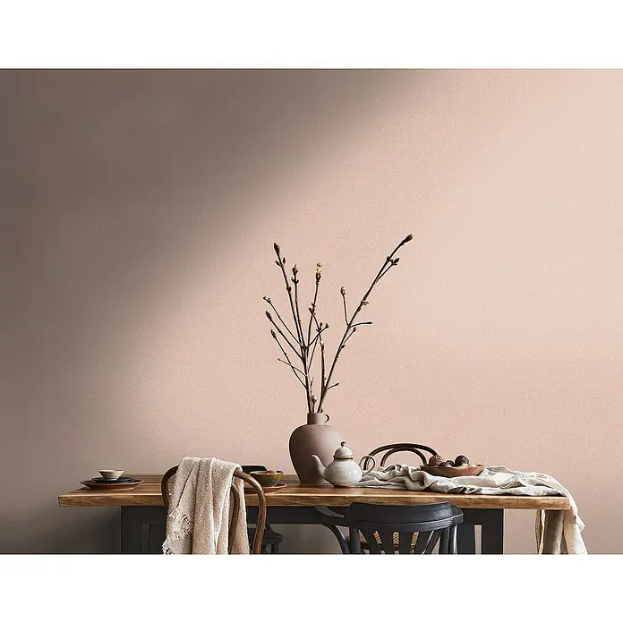 A.S. Création Metropolitan Stories Travel Styles Vliestapete - Melange-Rosè, Uni, 10,05 x 0,53 m - Ein gedeckter Tisch mit Geschirr, einem Teekessel und einer Vase mit Zweigen vor einer zweifarbigen Wand.