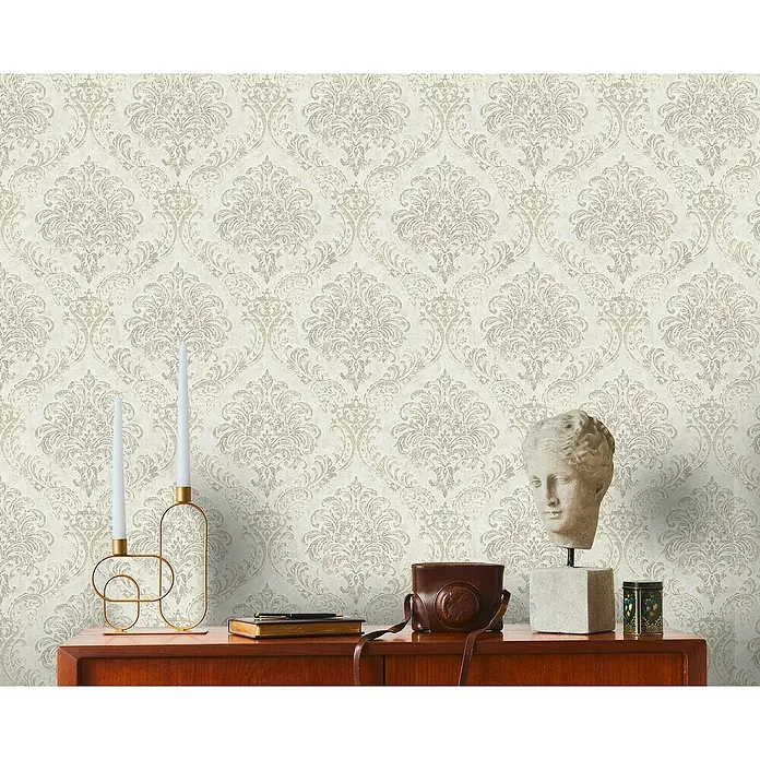 A.S. Création Metropolitan Stories Travel Styles Vliestapete DamaskWeiß/Silber, Ornament, 10,05 x 0,53 m - Nahaufnahme einer Kommode mit dekorativen Elementen und einer stilvollen Tapete im Hintergrund.