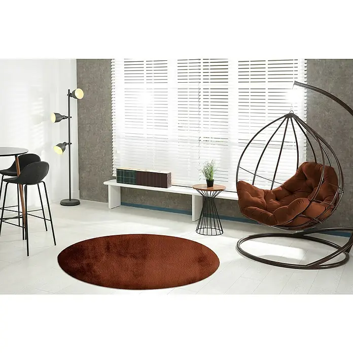 Fellteppich Happy - Terra, Durchmesser: 120 cm, 100 % Polyester (Flor) - Brauner, runder Teppich im modernen Wohnzimmer. Der Teppich ergänzt die stilvolle Einrichtung mit Hängekorb und minimalistischen Möbeln.