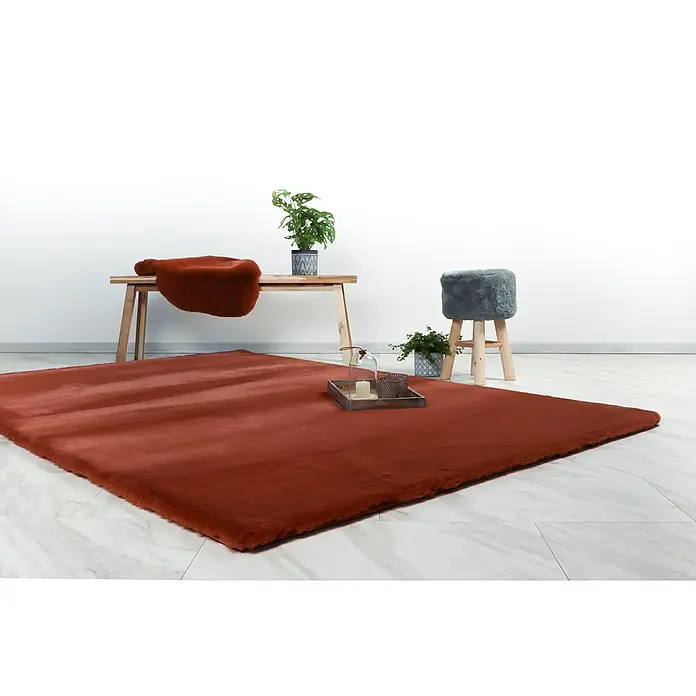 Fellteppich Happy - Terra, 230 x 160 cm, 100 % Polyester (Flor) - Brauner Teppich auf einem Marmorboden mit kleinem Hocker, Bank und Pflanzen für ein gemütliches Raumambiente.