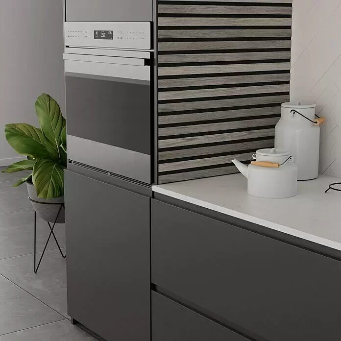 b!design Wandpaneel Wall Smart Plus - Eiche Grau, 2.500 x 300 mm - Moderne Küche mit dunkelgrauen Schränken, integriertem Backofen, weißer Arbeitsplatte und strukturierter Holzlamellenwand.