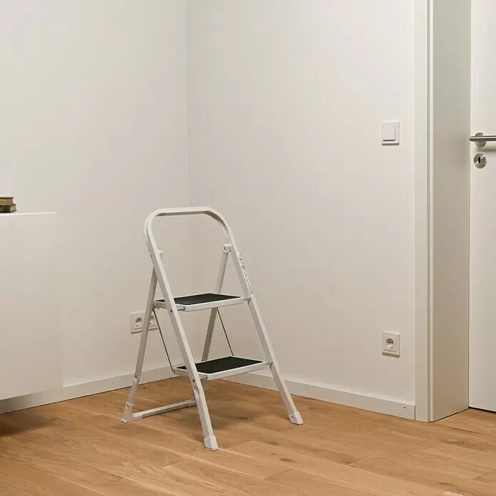 Klapptritt - Anzahl Tritte: 2 Stk., Arbeitshöhe: 2,45 m, Belastbarkeit: 150 kg, Stahl - Weißer klappbarer Zweistufen-Trittschemel mit schwarzen Stufen auf Holzboden.