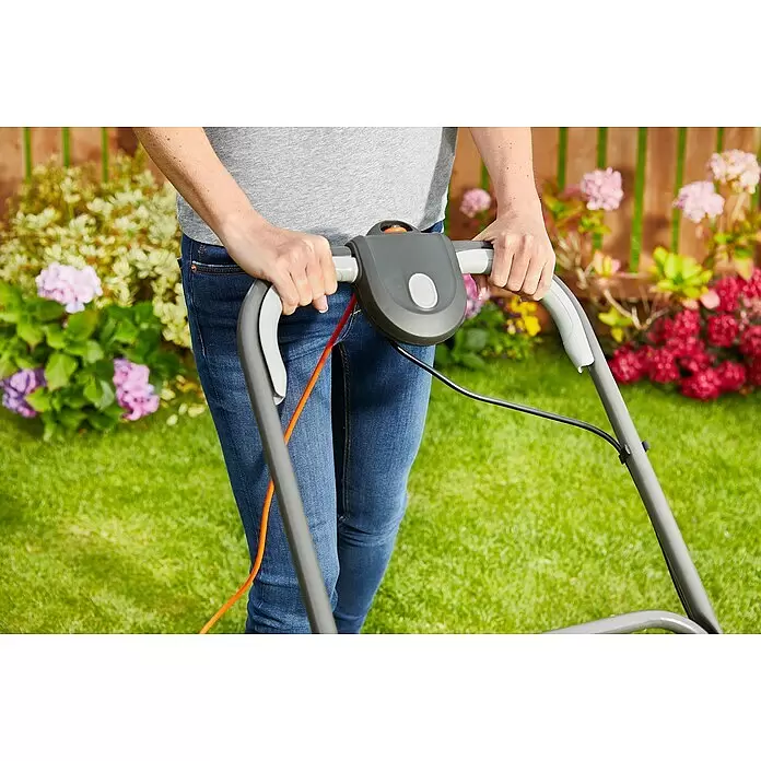 Flymo Elektro-Luftkissenmäher SimpliGlide 360 - Schnittbreite: 36 cm - Person bedient Rasenmäher, hält graue Griffe mit orangefarbenen und schwarzen Kabeln.