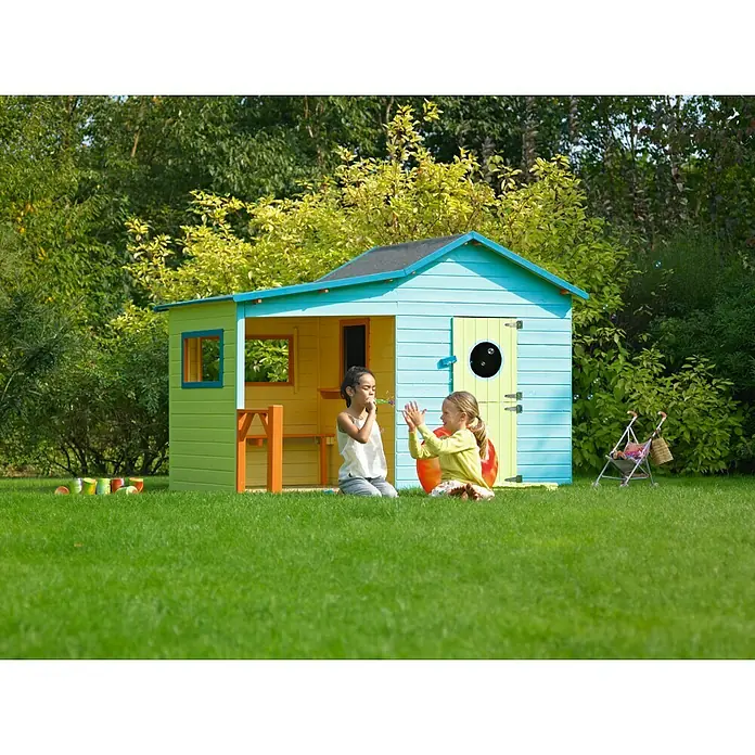 Soulet Spielhaus Hacienda - L x B x H: 243 x 125 x 175 cm, Holz, Natur - Ein farbenfrohes Spielhaus mit zwei Kindern auf einer grünen Wiese, die Seifenblasen blasen und klatschen.