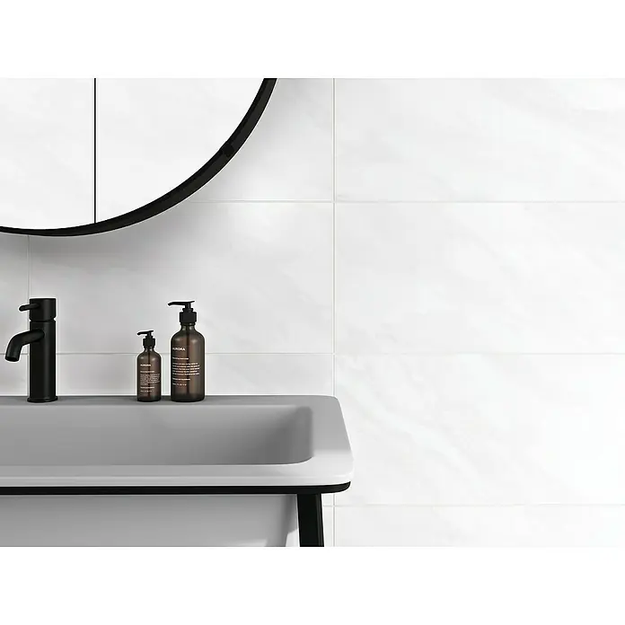 Wandfliese Venezia Grigio - 30 x 60 cm, Weiß, Glänzend - Nahaufnahme eines Badezimmers mit einem modernen Waschbecken, Armatur und zwei braunen Seifenspendern vor weißen Fliesen.