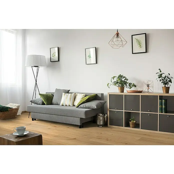 Classen Designbodenmuster Pro Nature Miranda - 246 x 200 x 4 mm, Landhausdiele - Ein stilvolles Wohnzimmer mit einem grauen Sofa, grünen Kissen und einer dekorativen Stehlampe, die eine gemütliche Atmosphäre schaffen.