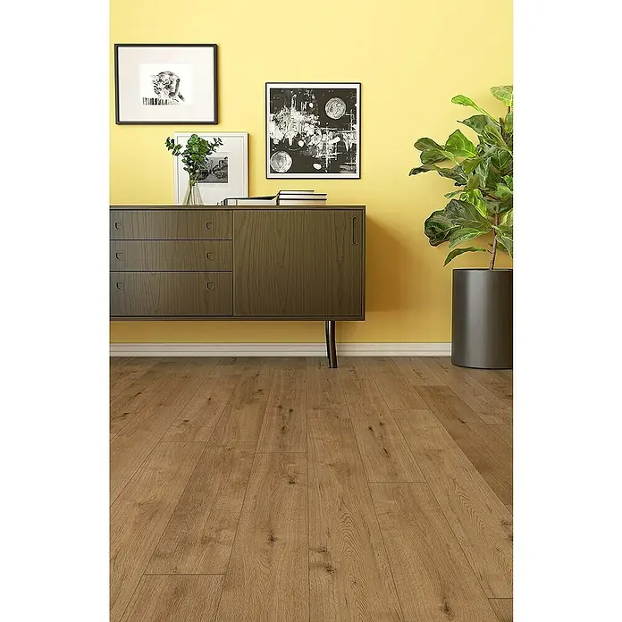 Classen Designboden Pro Nature - Barrow, Landhausdiele, 1.290 x 203 x 4 mm - Einrichtungsidee mit braunem Laminatboden, Sideboard, gerahmten Bildern und einer Zimmerpflanze vor gelber Wand für ein gemütliches Ambiente.