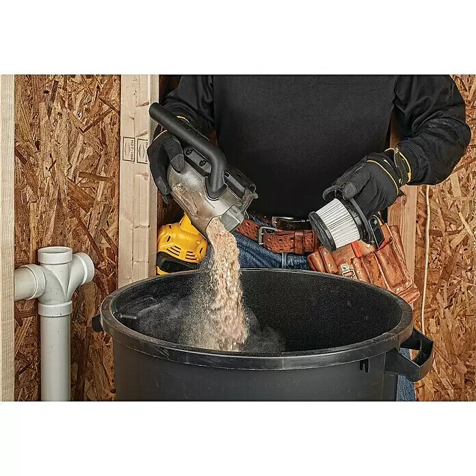 DeWalt XR 18V Akku-Handstaubsauger DCV501LN-XJ - 18 V, Ohne Akku, 0,75 l - Ein Arbeiter entleert Sägemehl aus einem Exzenterschleifer in einen schwarzen Behälter. Er hält auch den weißen Faltenfilter des Schleifers.
