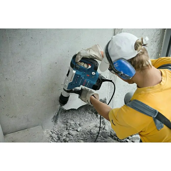 Bosch Professional Kombihammer GBH 5-40 DCE - 1.150 W, 8,8 J, SDS-Max-Aufnahme - Nahaufnahme eines Bauarbeiters, der mit einem Bosch Bohrhammer in eine Betonwand arbeitet, mit Schutzbrille und Handschuhen.