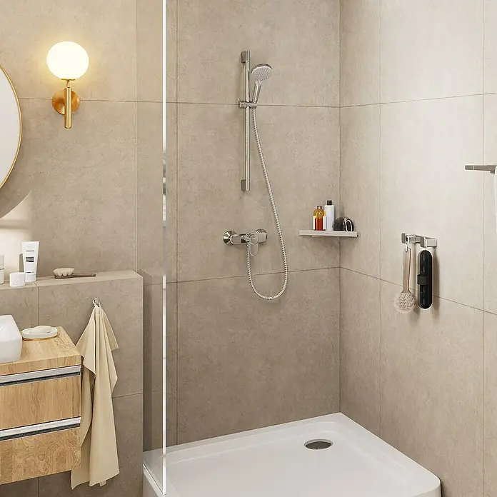 Hansgrohe Vernis Blend Brausegarnitur 100 Vario - Lochabstand: 62,5 cm, Art Strahl: Rain, IntenseRain, Chrom - Badezimmer-Szene mit Duscharmatur, Ablage mit Pflegeprodukten und Handtuchhalter. Die Armatur ist ein zentrales Element im Raum.