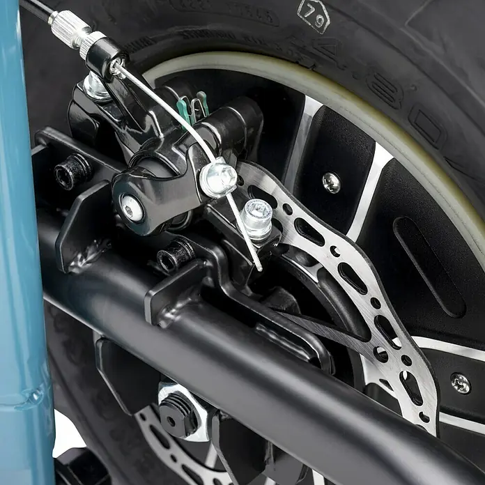 Makita LXT 18V Akku-Schubkarre DCU180Z - 18 V, Ohne Akku, Tragkraft: 130 kg - Nahaufnahme einer Fahrradscheibenbremse mit Kabelzugsystem, das die Bremskraft auf die Bremsscheibe überträgt.