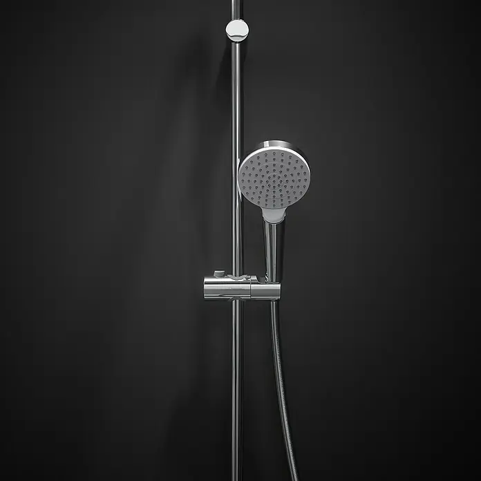 Hansgrohe Crometta Brausegarnitur 100 Green - Lochabstand: 62,5 cm, Art Strahl: Rain, Chrom - Nahaufnahme einer modernen Duscharmatur aus Chrom mit rundem Duschkopf vor einem dunklen Hintergrund.